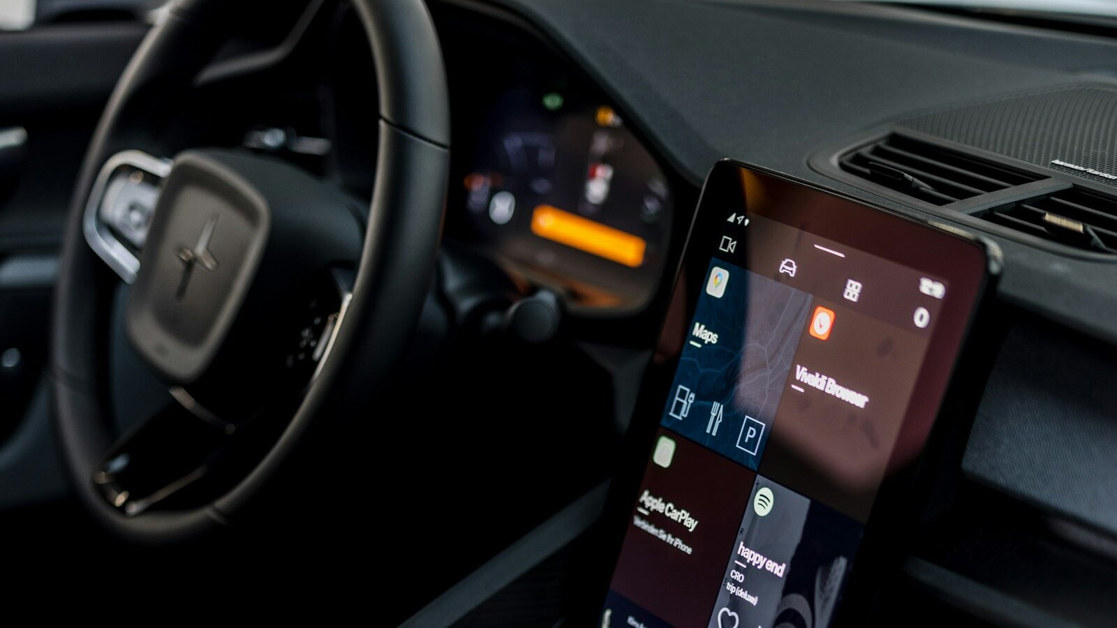 Photo of a car interior with a CarPlay screen and steering wheel