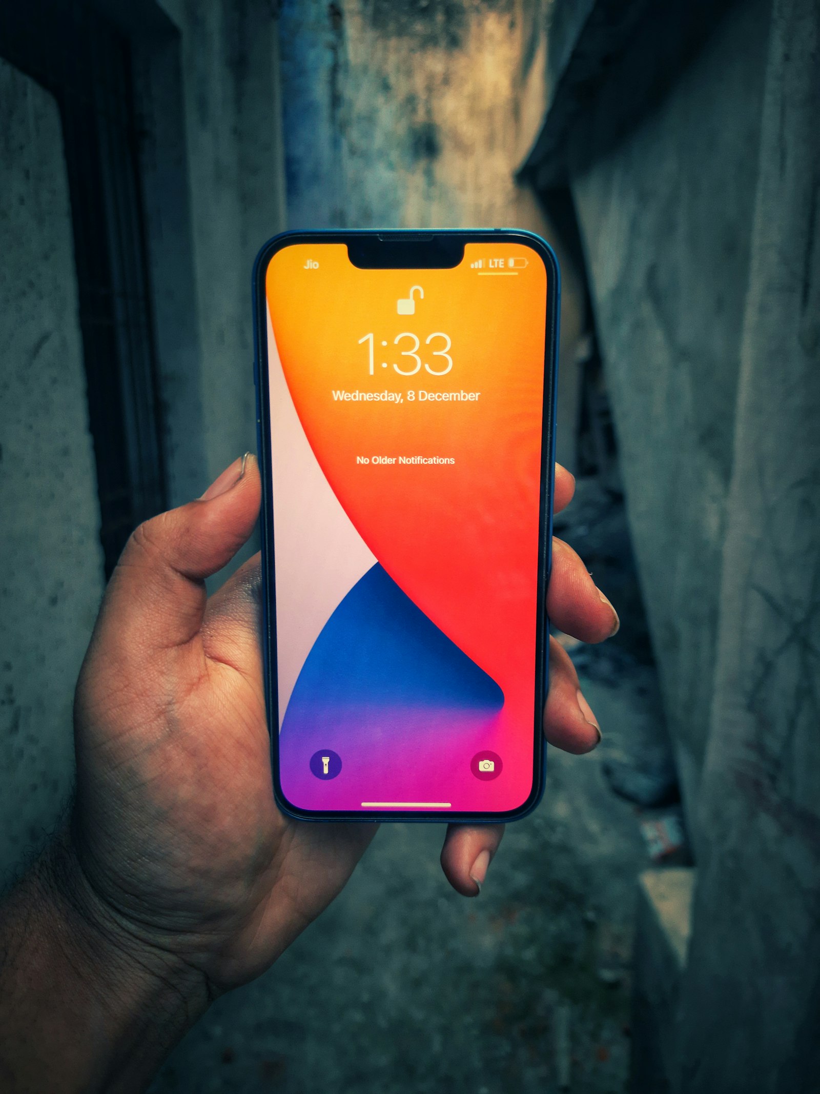 An iPhone held in one hand, showing its lock screen