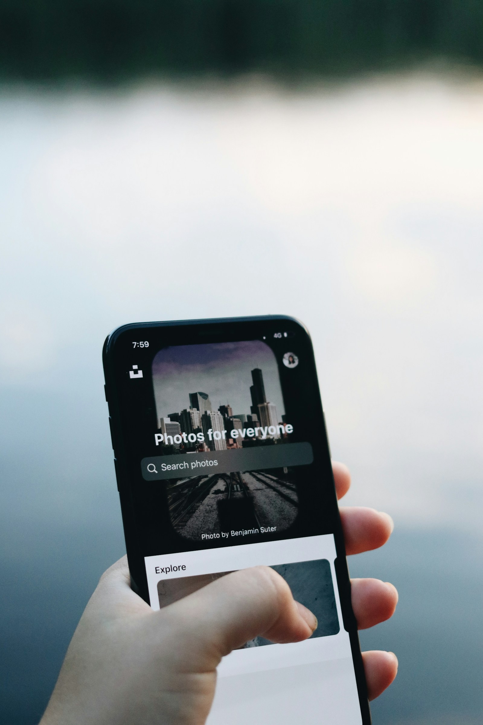 A hand holding a smartphone while browsing digital content