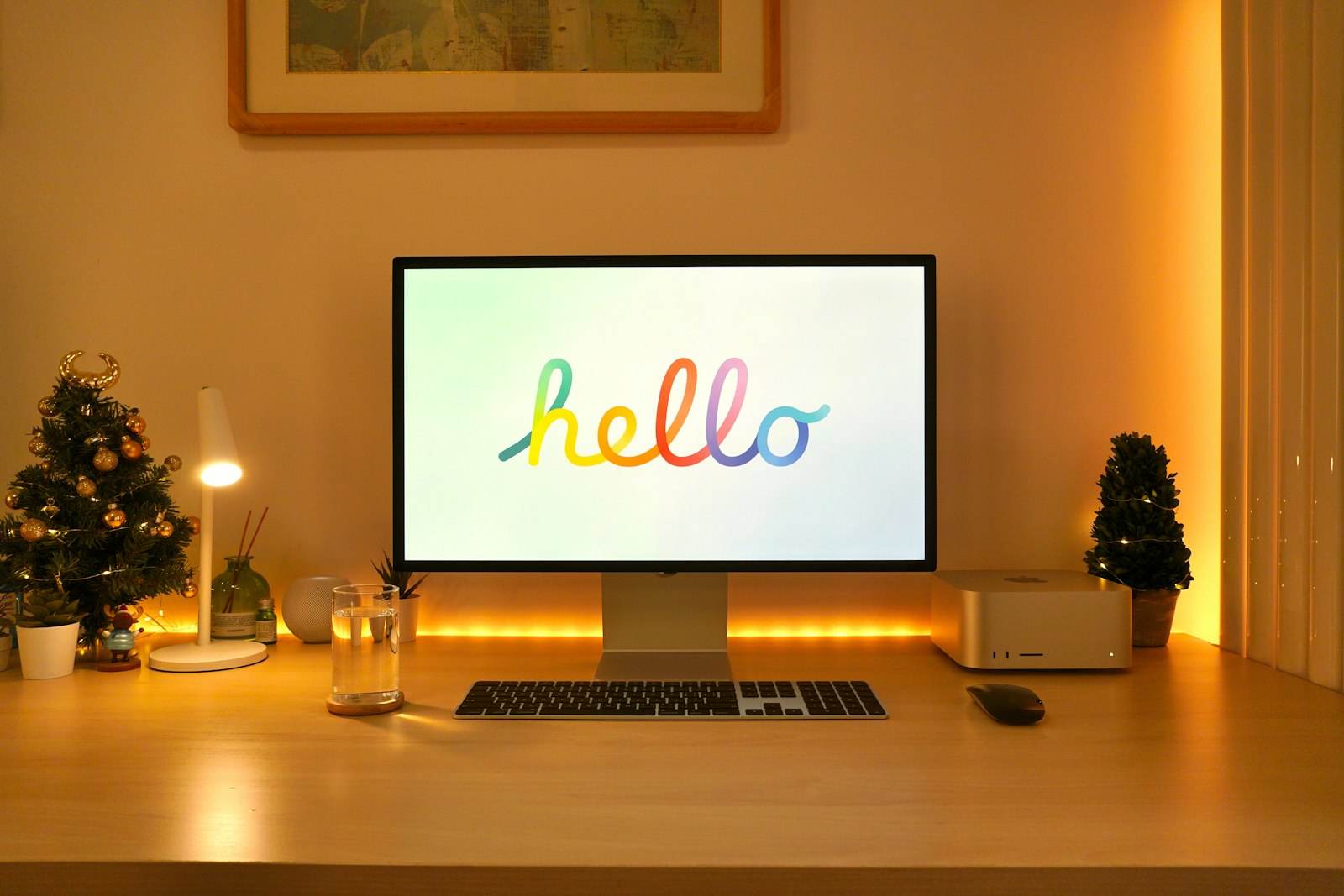 A Mac Studio beside a Studio Display showing the Hello start-up screen. Contextual photograph; it does not show the new chips or macOS Golden Gate.