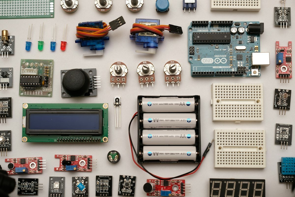 Illustration image: a flat lay of electronics components, with an Arduino board, sensors, breadboards and a holder of four AA rechargeable cells marked 1900 mAh.