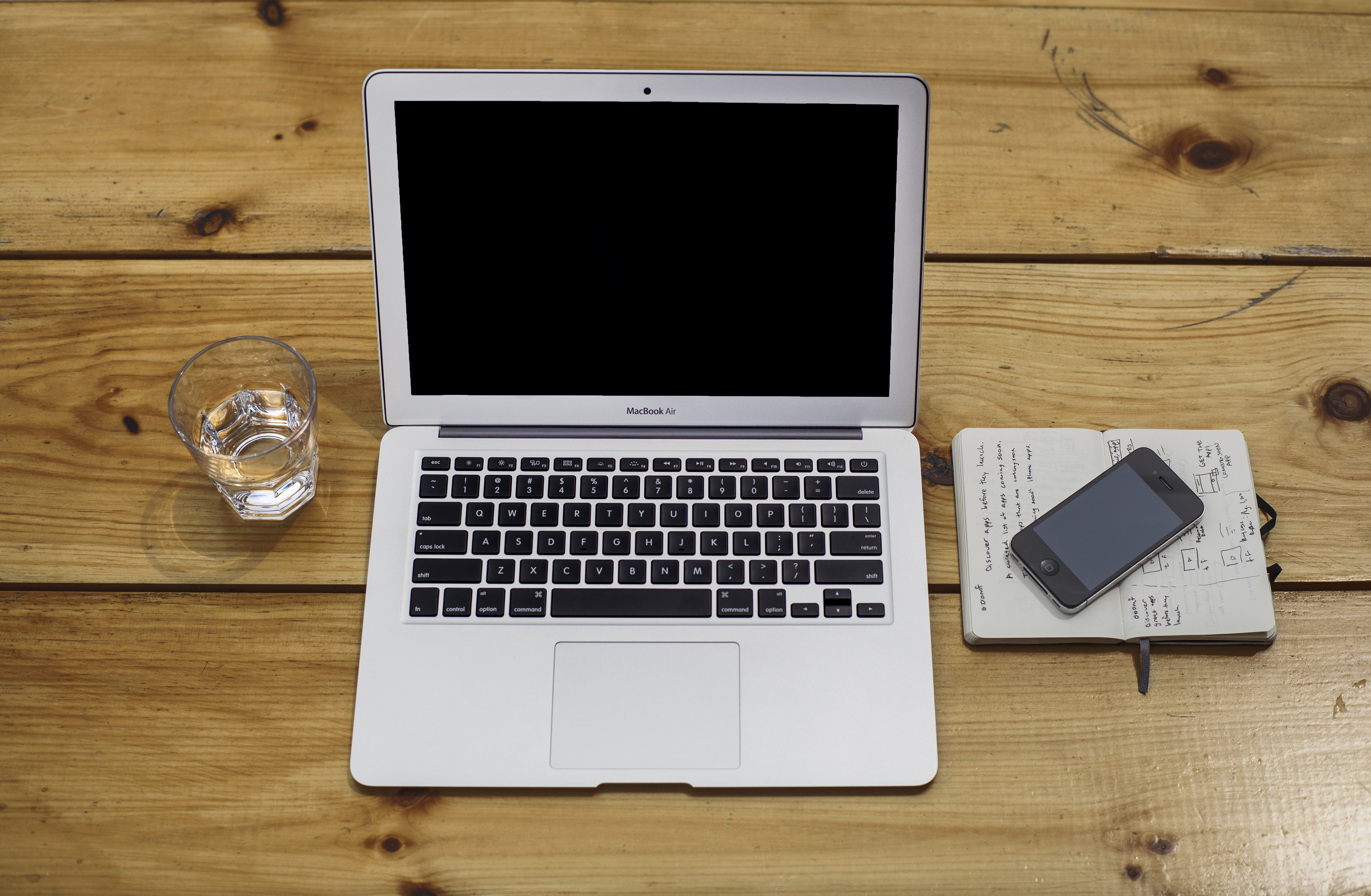 Un MacBook Air photographié de dessus sur une table en bois ; photographie de contexte pour les autorisations de confidentialité de macOS.